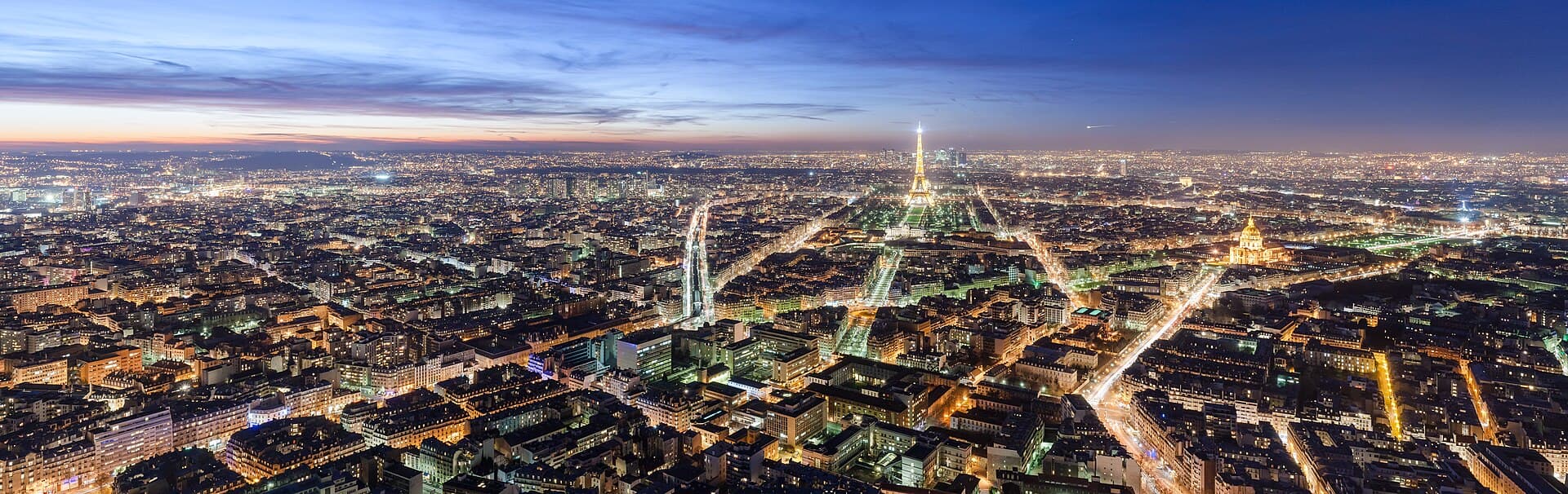 The Paris skyline at dusk with the Eiffel Tower glowing
